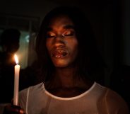 A member of the trans community holds candles during the vigil of the Transgender day of Remembrance