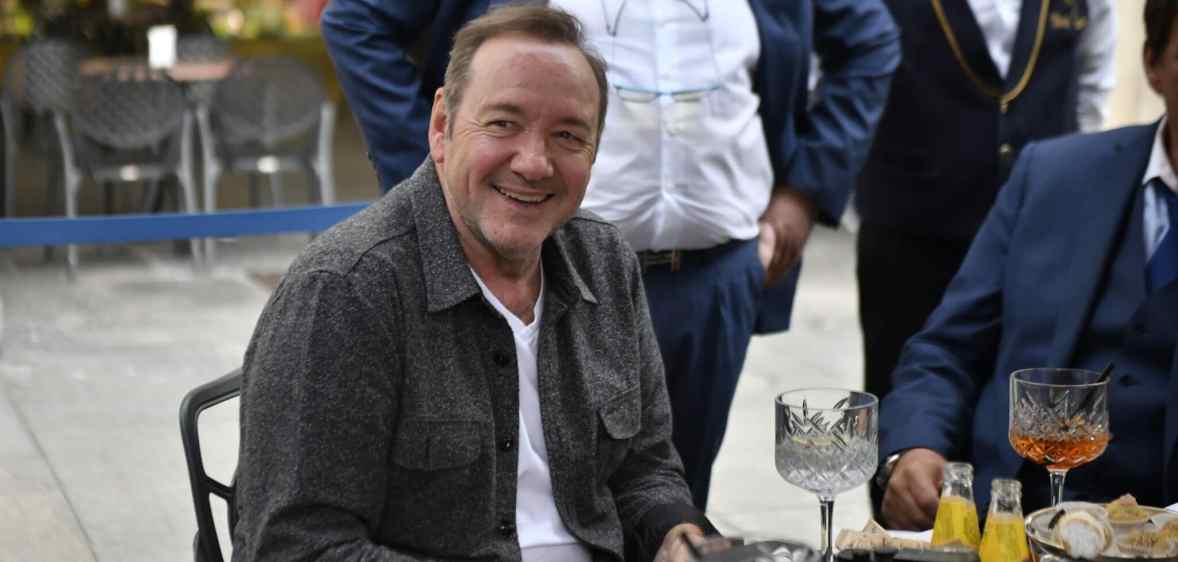 Kevin Spacey is seen sitting outside a cafe