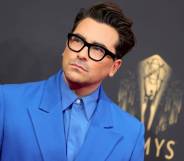 Dan Levy is seen wearing a light blue collared shirt with a slightly darker blue jacket at the 73rd Primetime Emmy Awards in September