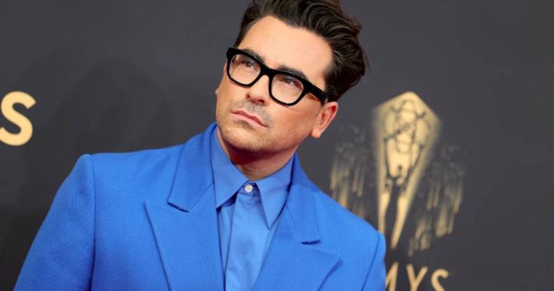 Dan Levy is seen wearing a light blue collared shirt with a slightly darker blue jacket at the 73rd Primetime Emmy Awards in September