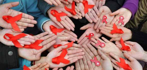 University students display red ribbons during an event to promote the awareness of AIDS at the Sichuan University on World AIDS Day 2009.