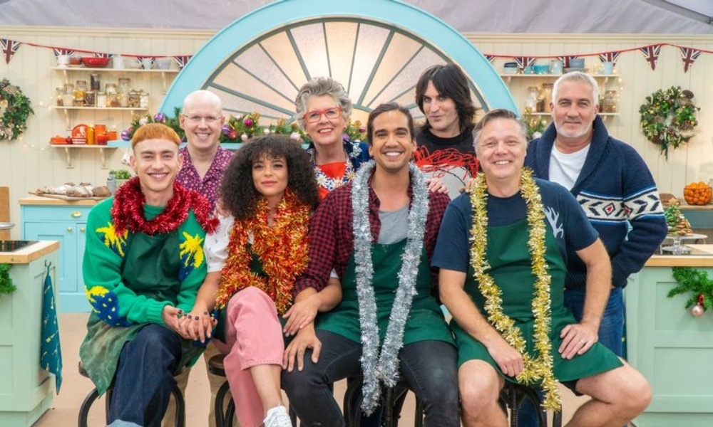 The It's a Sin cast posing alongside the GBBO judges and hosts