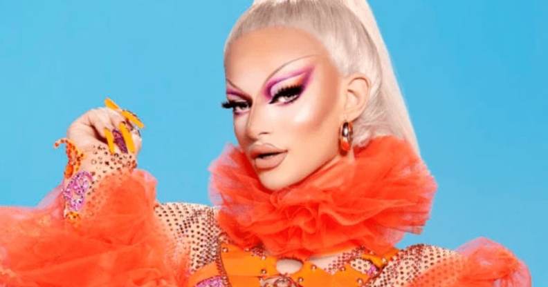 Krystal Versace poses in an orange outfit against a blue background