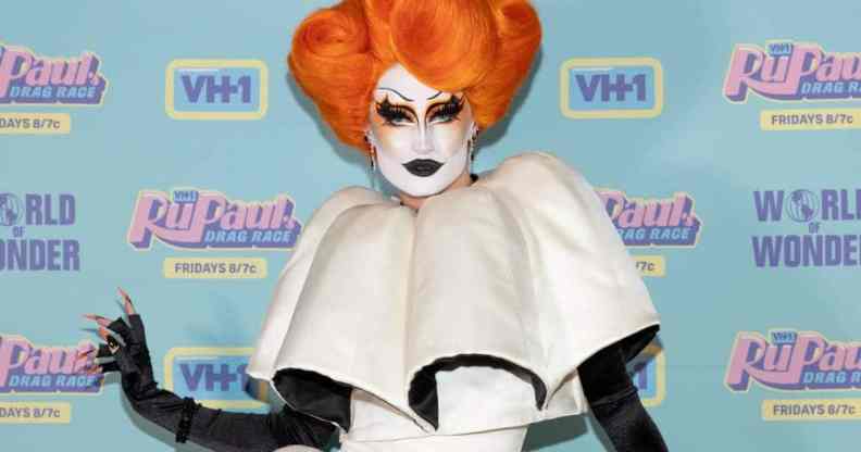 Gottmik poses in front of cameras at the season finale for RuPaul's Drag Race season 13