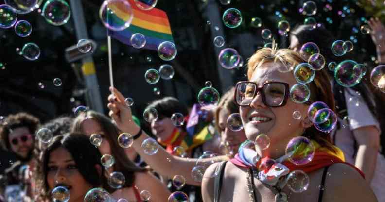 Members of the LGBT+ community in Switzerland celebrate Zurich Pride holding rainbow LGBT+ flags and walking through a wave of bubbles