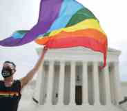 A person holds an LGBTQ+ Pride flag outside the US Supreme Court