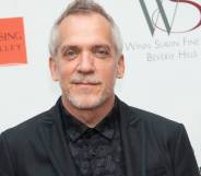 Director Jean-Marc Vallée poses in a black shirt and suit jacket in front of a white background