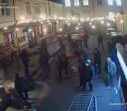 Several people in dark clothes are captured on camera destroying the outside of HvLv, a gay bar in Kyiv, Ukraine
