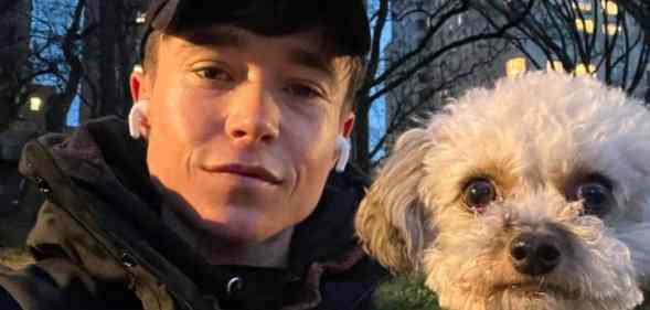 Elliot Page poses alongside small white dog outside