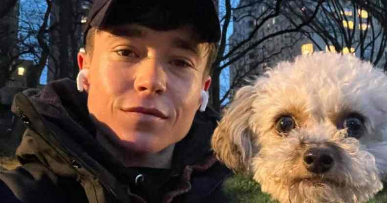 Elliot Page poses alongside small white dog outside