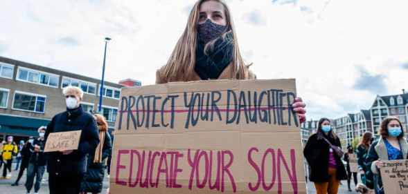 A woman holding a sign with 'protect your daughters' crossed out, and 'educate your son' written underneath