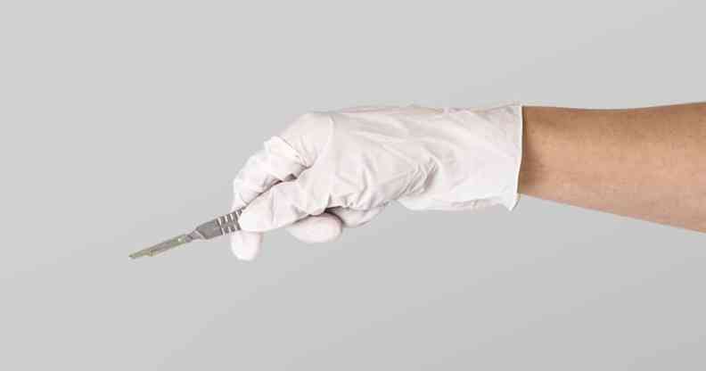 Gloved hand holding scalpel
