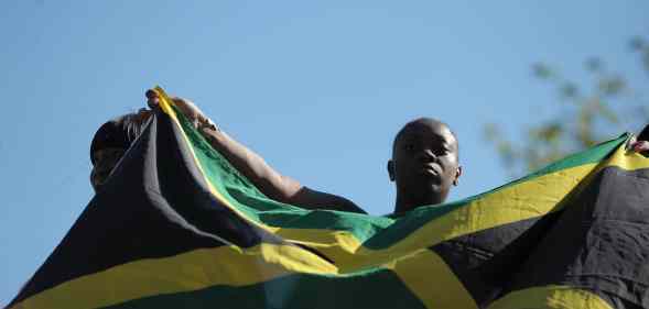 A woman holds up the flag of Jamaica