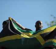 A woman holds up the flag of Jamaica