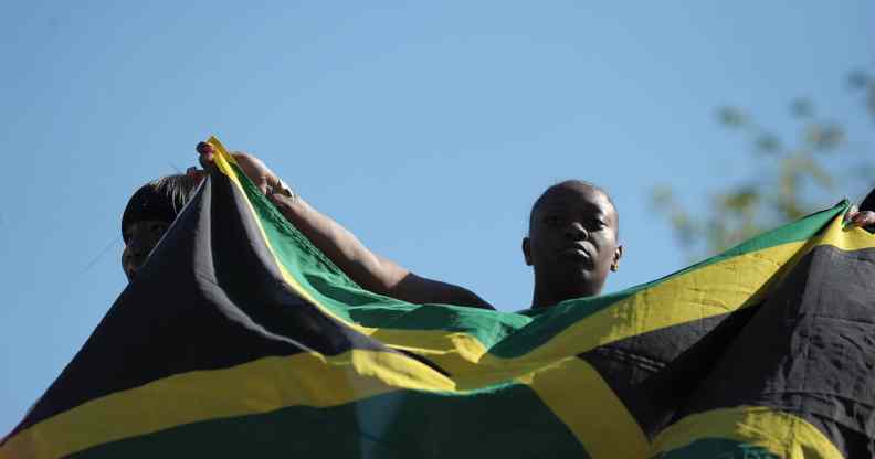 A woman holds up the flag of Jamaica