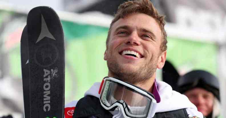 Gus Kenworthy wears ski gear while smiling up