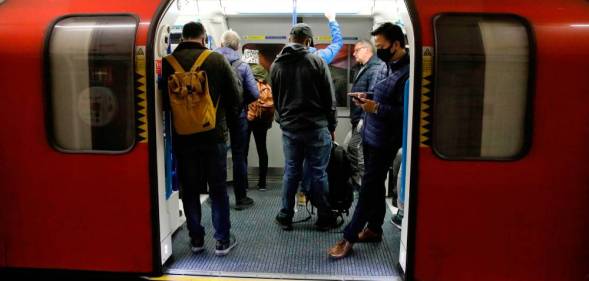 Commuters wearing PPE, including a face mask, while on travelling on the morning rush hour on the TfL