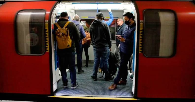 Commuters wearing PPE, including a face mask, while on travelling on the morning rush hour on the TfL