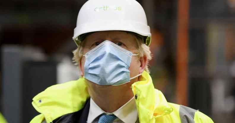 Boris Johnson wearing a hard hat and orange hi-res jacket over his suit