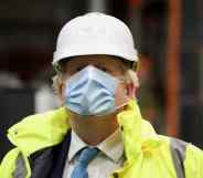 Boris Johnson wearing a hard hat and orange hi-res jacket over his suit