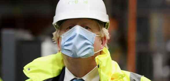 Boris Johnson wearing a hard hat and orange hi-res jacket over his suit