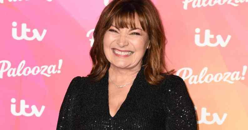 Lorraine Kelly smiles at the camera while wearing a black sparkly outfit
