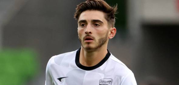 Joshua Cavallo wears a white and black patterned football jersey as he warms up before a match