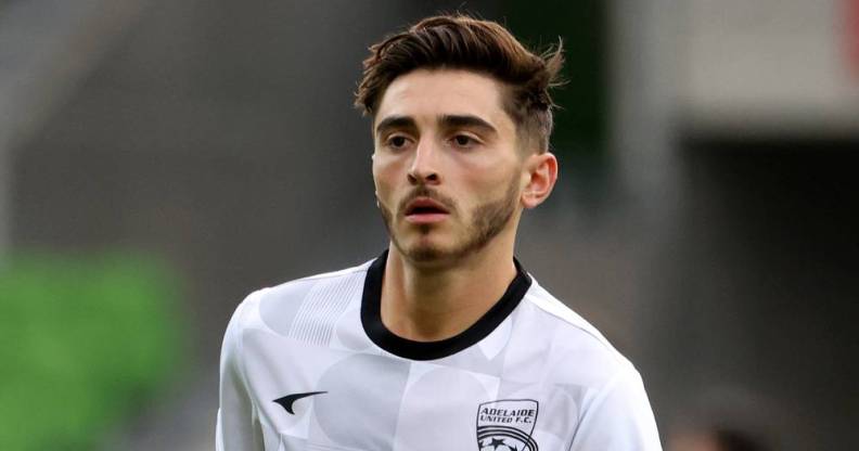 Joshua Cavallo wears a white and black patterned football jersey as he warms up before a match