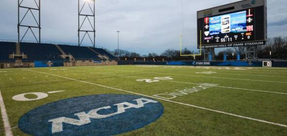 An empty playing field with the NCAA logo on it