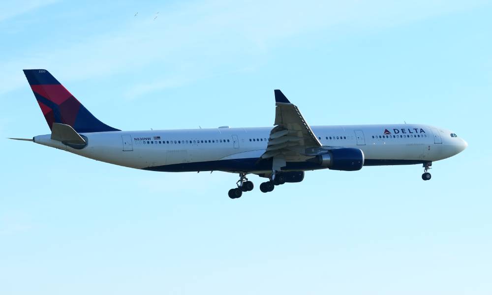 A Delta branded airplane flies in a blue sky