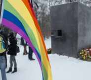 A man holds a rainbow flag during an event to commemorate the homosexual men and women who were persecuted by the Nazis dunring the Holocaust on January 27, 2014 in Berlin, Germany.