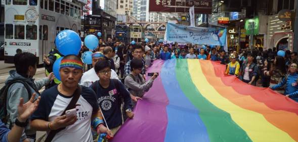 Participants of Hong Kong's annual pride parade march with a giant rainbow flag