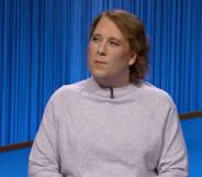 Amy Schneider appears on the set of Jeopardy! in a grey or cream top