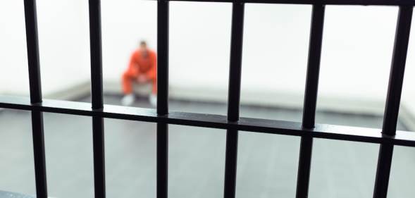 A prisoner behind bars.