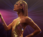 A performer in a gold headpiece holding a peach