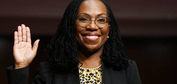 Ketanji Brown Jackson, a Black woman, raises her hand as she is sworn in before a Senate Judiciary Committee hearing