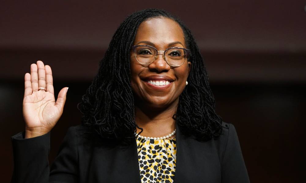 Ketanji Brown Jackson, a Black woman, raises her hand as she is sworn in before a Senate Judiciary Committee hearing