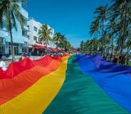 A rainbow flag flies over Ocean Drive as people participate in a Pride parade at a Pride festival in Florida