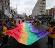 Activists hold the rainbow flag on Volodymyrska Street during the Equality March.
