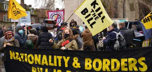 Demonstrators hold a banner and flags with slogans during the rally.
