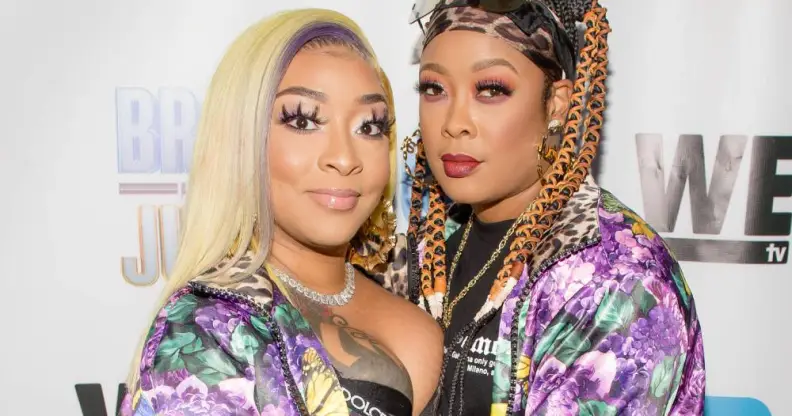 Jesseca Dupart and Da Brat stare at the camera while wearing pink and purple patterned tops