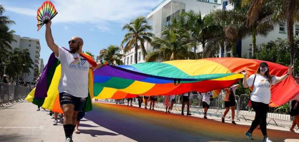 People carry the Rainbow Flag as they participate in the Miami Beach Pride Parade