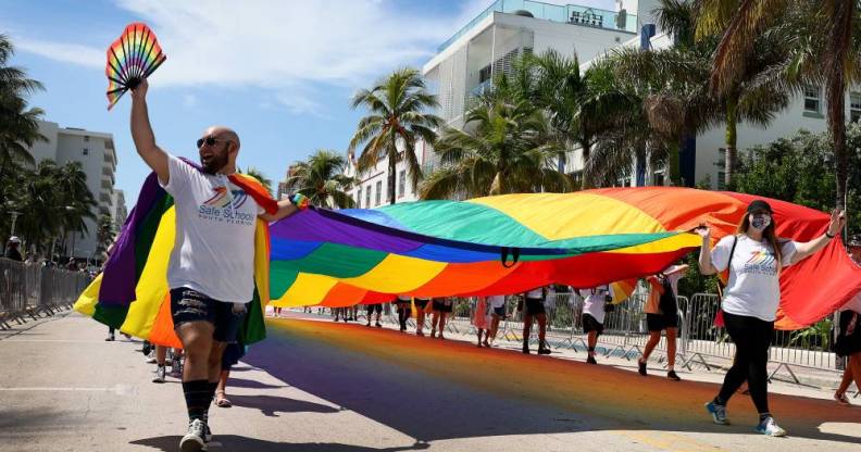 People carry the Rainbow Flag as they participate in the Miami Beach Pride Parade
