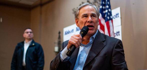 Texas governor Greg Abbott, a white man, speaks into a microphone as he addresses a crowd