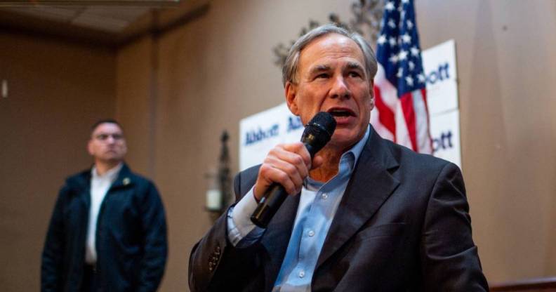 Texas governor Greg Abbott, a white man, speaks into a microphone as he addresses a crowd