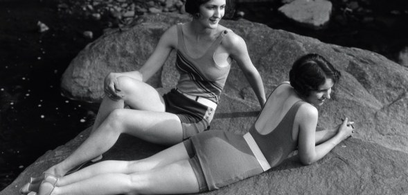 Two women relaxing on a rock in the 1920s