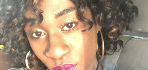 Naomie Skinner, a Black trans woman, is seen with hoop earrings and berry coloured lip tiny