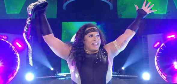 Nyla Rose, a wrestler, holds up a championship belt above her head after a victory in the ring