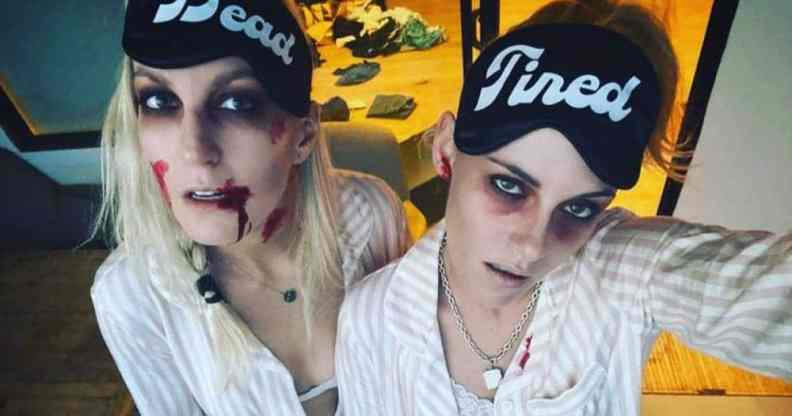 Dylan Meyer and Kristen Stewart dress up as zombies with pale complexions and fake blood while wearing eye masks that read 'dead tired'