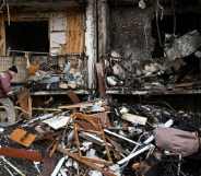A man clears debris at a damaged residential building at Koshytsa Street, a suburb of the Ukrainian capital Kyiv, where a military shell allegedly hit, on February 25, 2022.